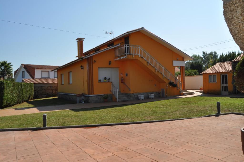 an orange house with a staircase in front of it at CASA AUREA DE CACHEIRAS in O Grove