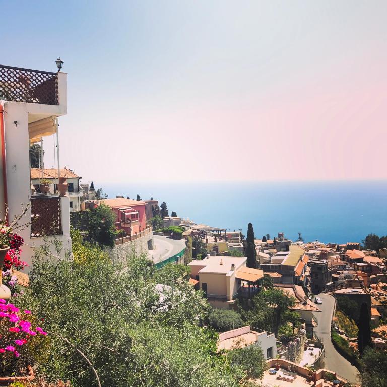 a view of a town with the ocean in the background at Villa Greta Hotel Rooms & Suites in Taormina