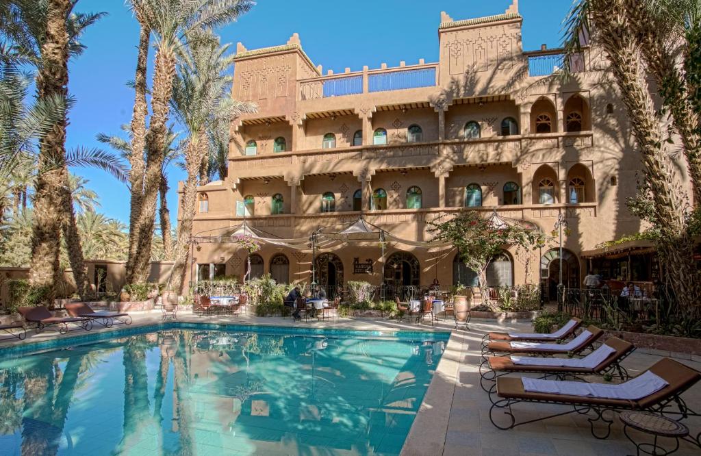 a hotel with a swimming pool in front of a building at Kasbah Sirocco in Zagora