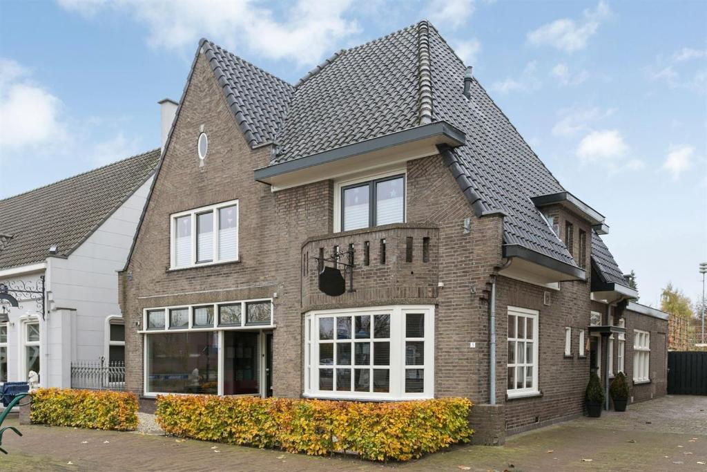 una casa de ladrillo marrón con techo gris en B&BbyBerry en Lieshout