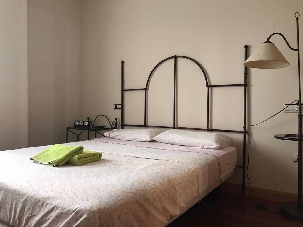 Un dormitorio con una cama con una toalla verde. en Villa de Madrid 17, en Huelva