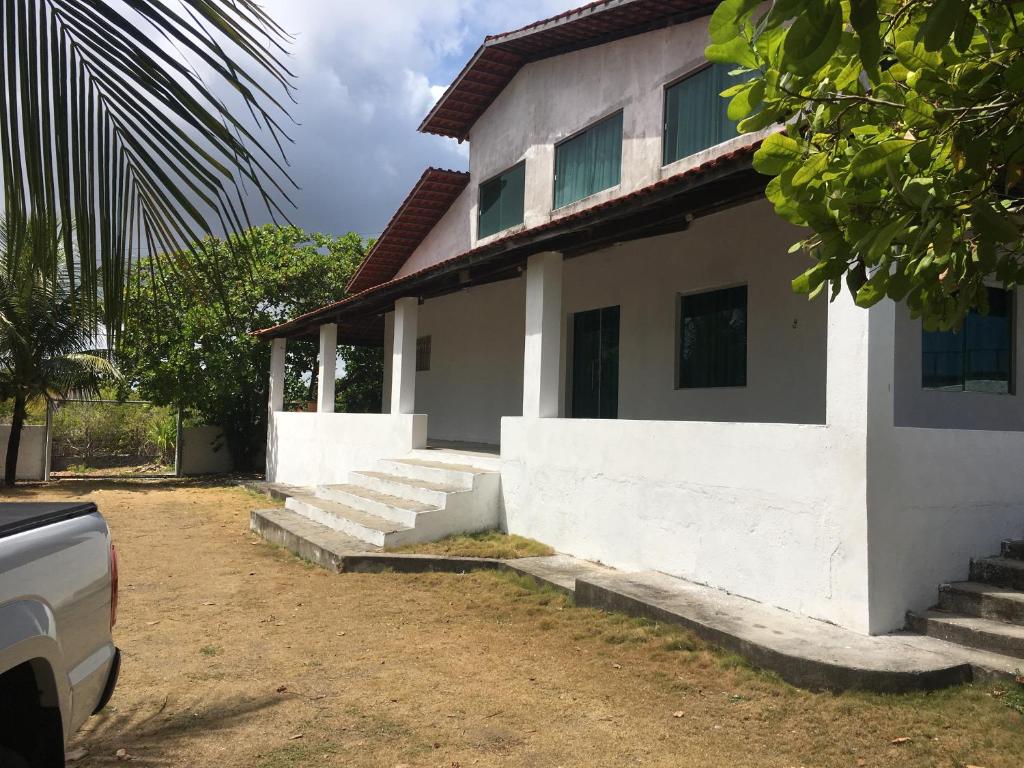 a white house with steps leading up to it at Casa de praia em Carapibus in Conde