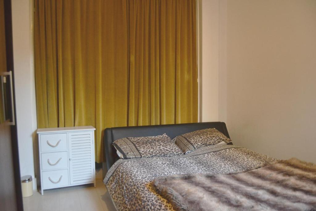 ロンドンにあるSuperb Double Bedroomのベッドルーム1室(ベッド1台付)、窓(緑のカーテン付)