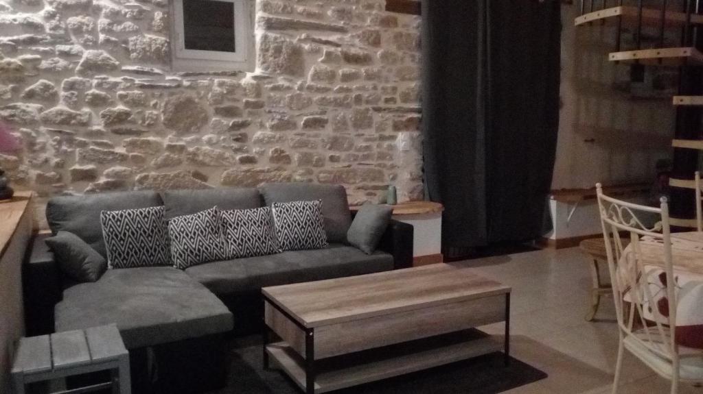 a living room with a couch and a stone wall at Penandaouent in Commana