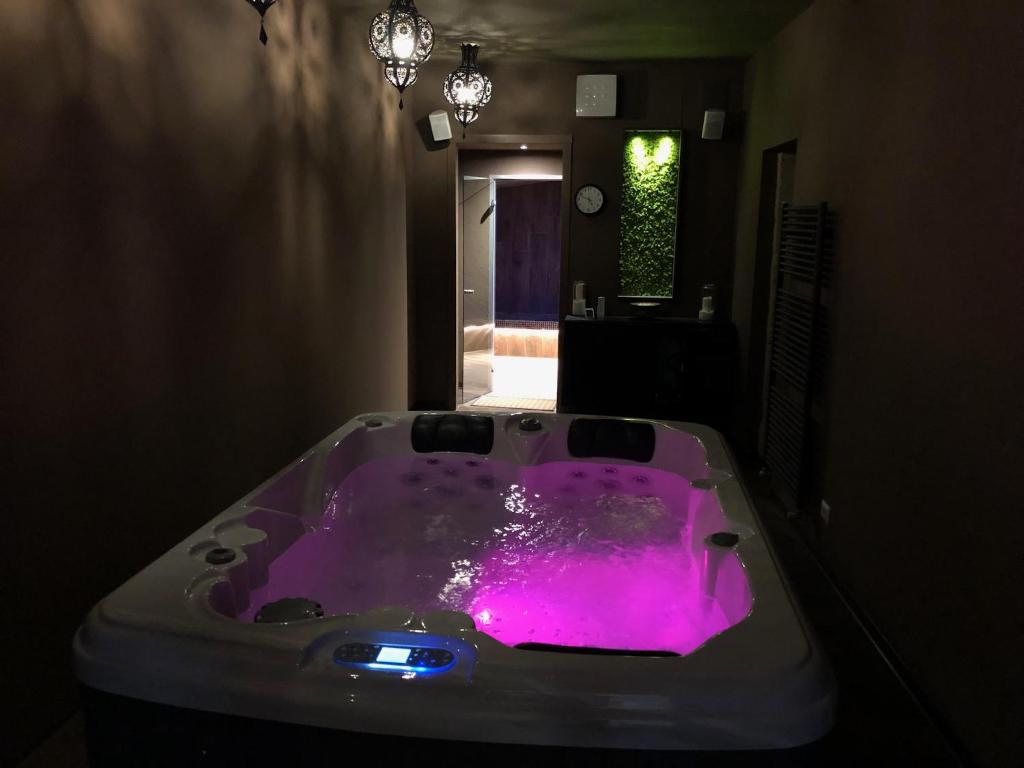 una vasca da bagno viola in una camera oscura di La Rocca Guest House & Spa a Montefalco