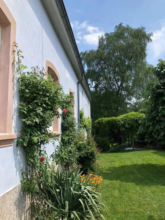 a house with flowers on the side of it at Ferienwohnung Maurer in Hasborn-Dautweiler
