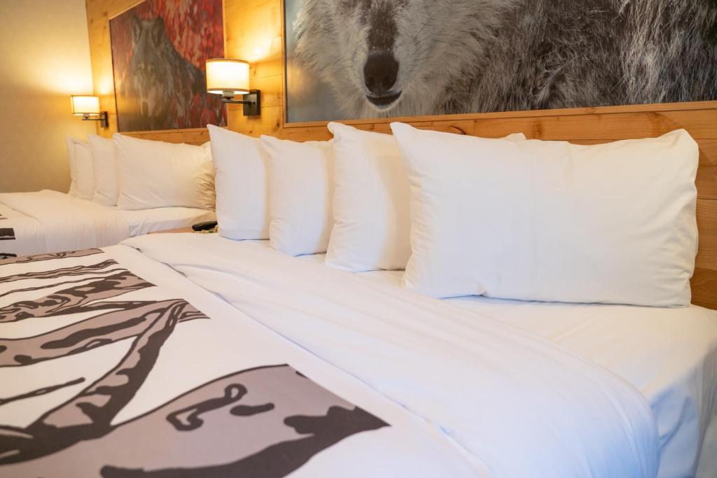 two beds with white pillows in a hotel room at Banff Rocky Mountain Resort in Banff