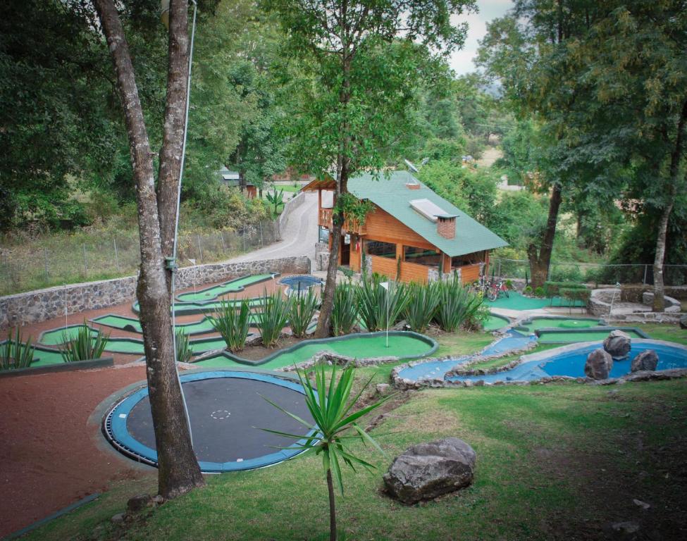 a resort with a slide and a swimming pool with a house at Cabañas El Estribo Hotel in Valle de Bravo