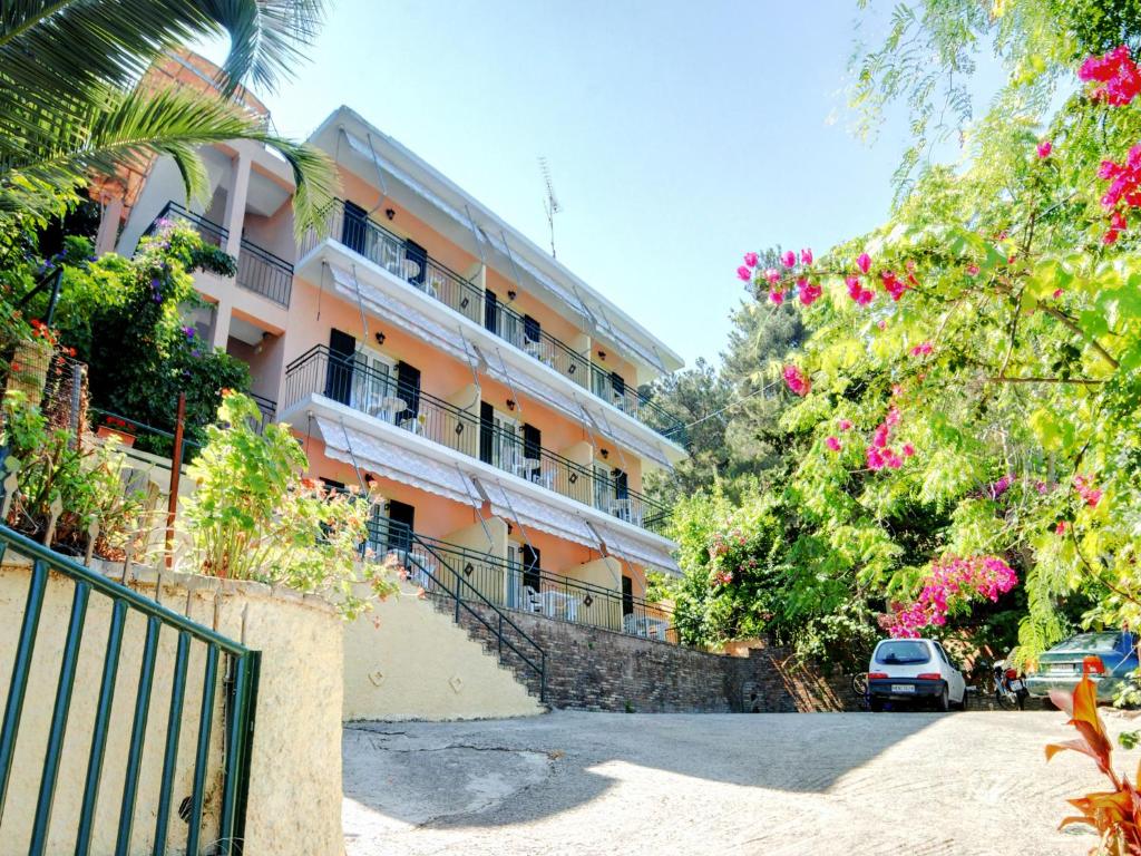um edifício laranja com varandas, árvores e flores em Empress Corfu em Perama