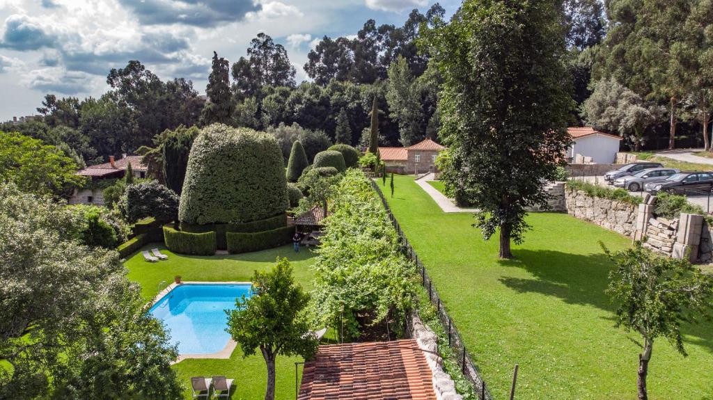 a lush green garden with trees and shrubbery at Villa Margaridi in Guimarães
