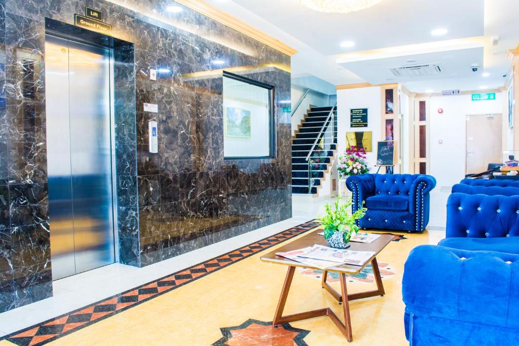 a lobby with two blue chairs and a table at Al Afiah Hotel in Bandar Seri Begawan