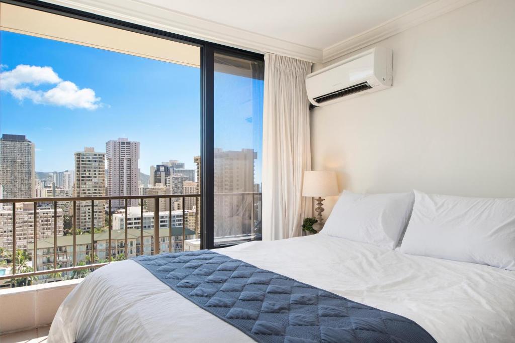 ein Schlafzimmer mit einem Bett und einem großen Fenster in der Unterkunft Royal Garden at Waikiki in Honolulu