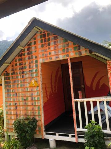 a brick house with a porch and a balcony at Beach Shack Chalet - Garden View Aframe Big Unit in Tioman Island