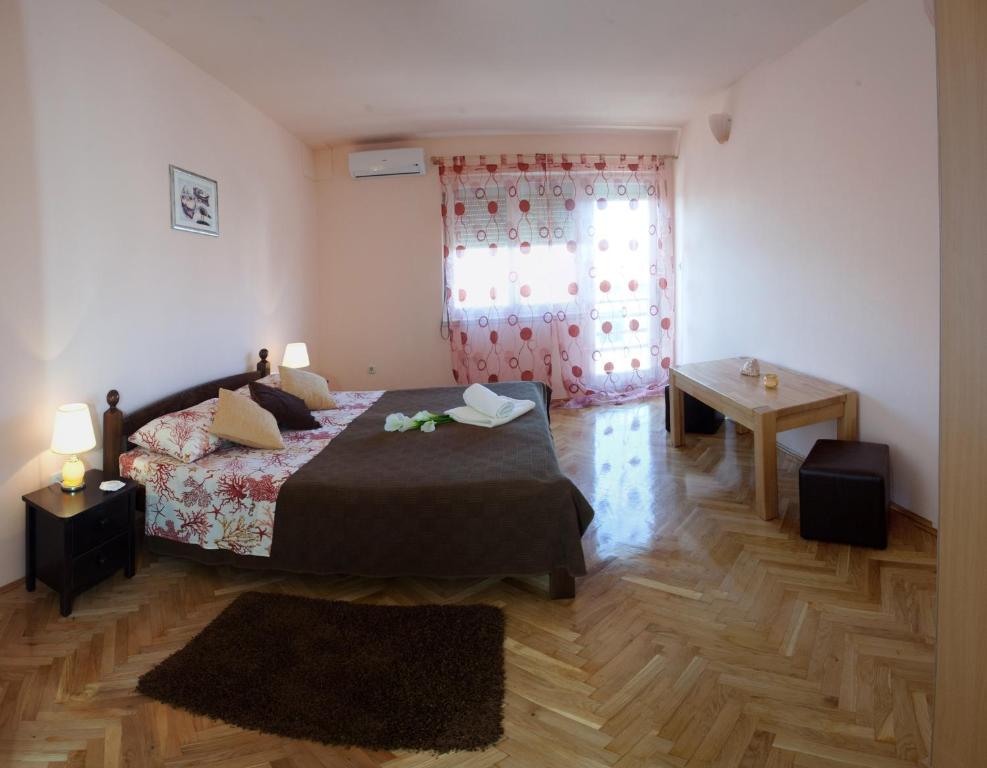 a bedroom with a bed and a window at Apartments Beautiful Sandy Beach in Split