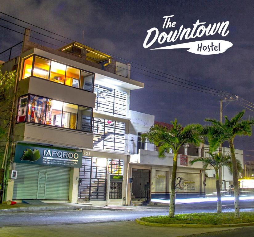 un edificio de noche con un cartel que lee el hotel del centro en Downtown Hostel Chetumal en Chetumal