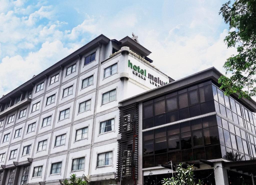 um grande edifício branco com um cartaz em Hotel Maluri em Kuala Lumpur
