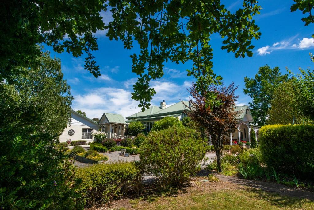 a house with a yard with bushes and trees at Yarra Gables in Healesville