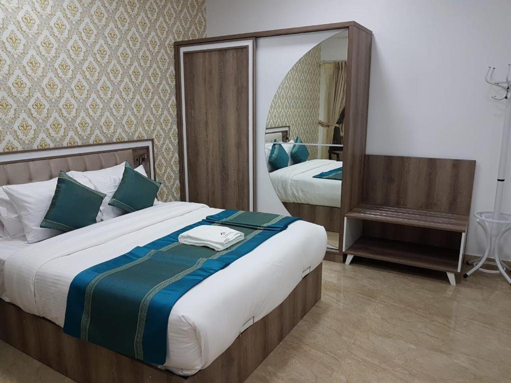 um quarto com 2 camas e um espelho grande em Orient Apartments em Nizwa
