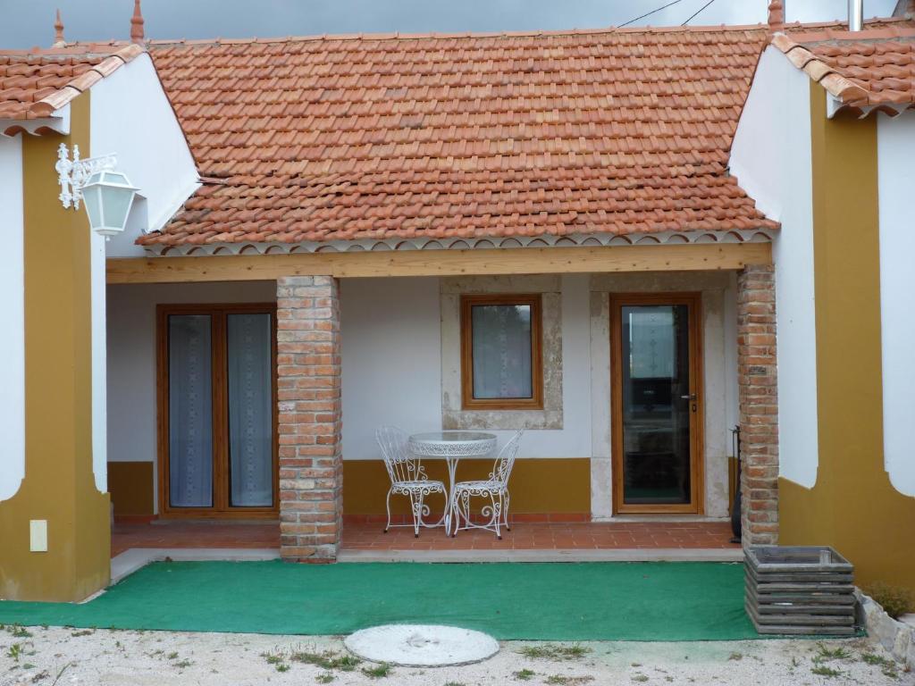 a house with a red roof and a table and chairs at Refugio da Ti Maria in Batalha