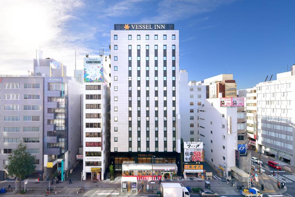名古屋市にあるVessel Inn Sakae Ekimaeの交通のあった都市の白い高い建物