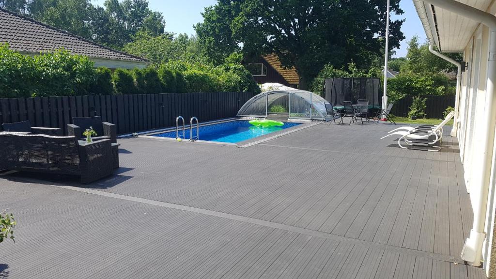 a backyard with a swimming pool and a fence at Poolvilla i Höllviken in Höllviken