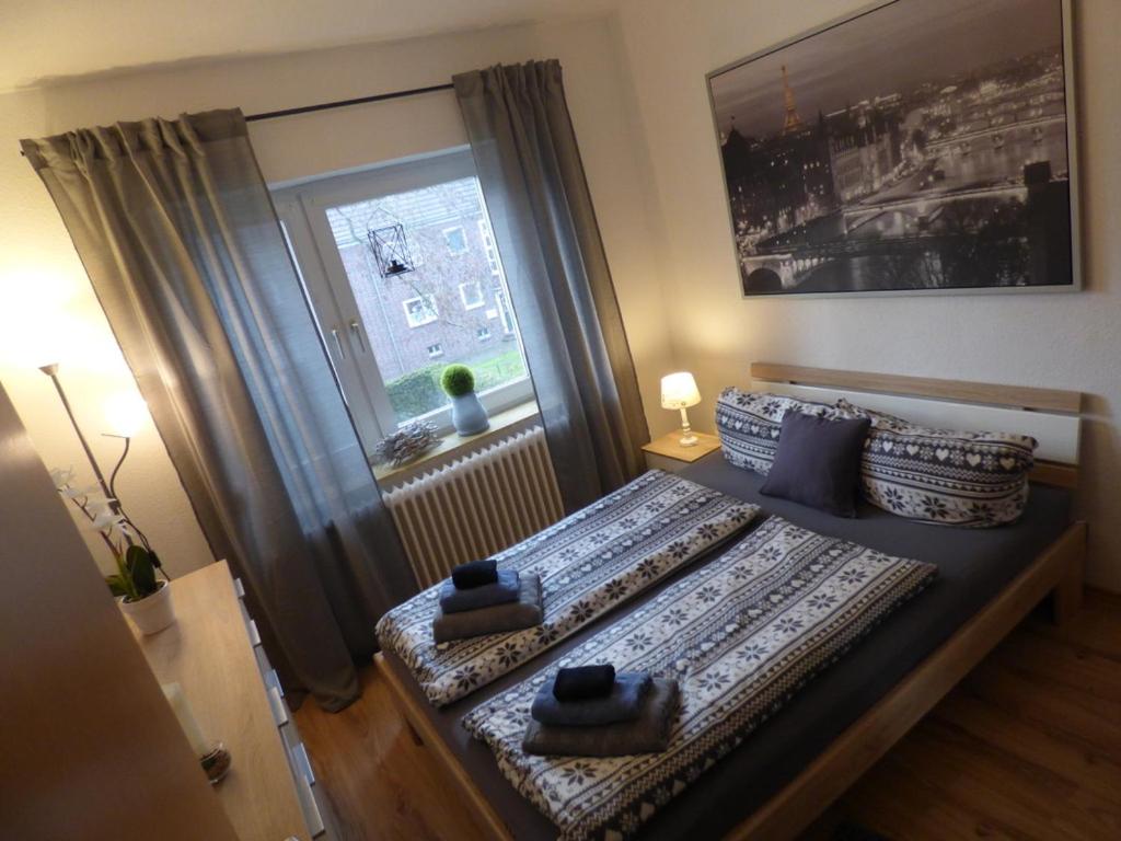 ein Schlafzimmer mit einem Bett mit Kissen und einem Fenster in der Unterkunft Apartmenthaus Geniusbank OL in Wilhelmshaven