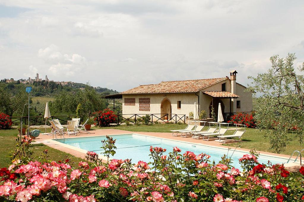 a house with a swimming pool in front of a house at Le Fonti Di Santa Lucia in San Gimignano