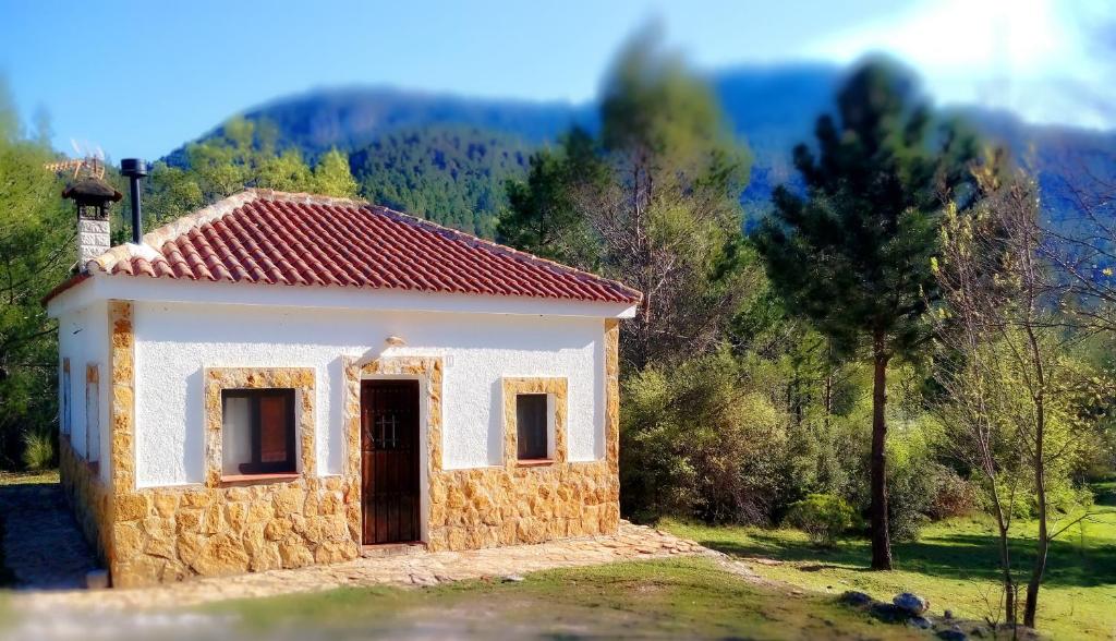 a small white house with a red roof at Casa Rural en Aldea Cueva Ahumada in Villaverde de Guadalimar