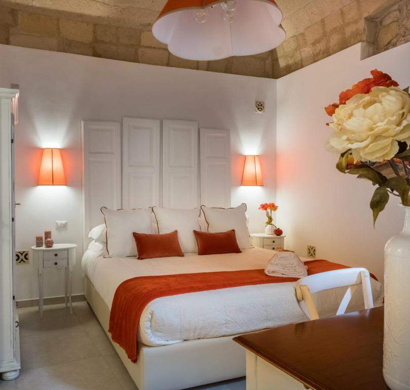 1 dormitorio con 1 cama blanca grande con sábanas de color naranja en Amatè Suite, en Lecce