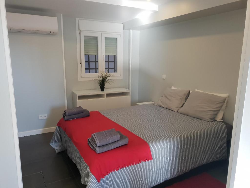 1 dormitorio con 1 cama con manta roja en WindRose 0 en Madrid