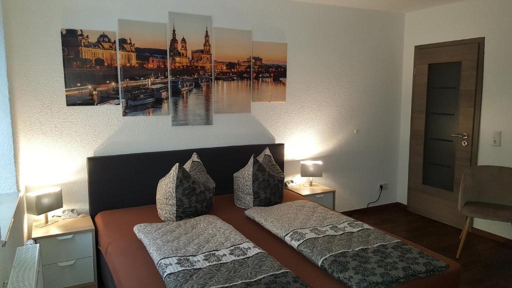 ドレスデンにあるFerienwohnung oder Studio Dresden-Neustadt inkl Parkplatz mit Balkon oder Terrasseのベッドルーム1室(ベッド2台付)が備わります。壁には絵画が2点飾られています。