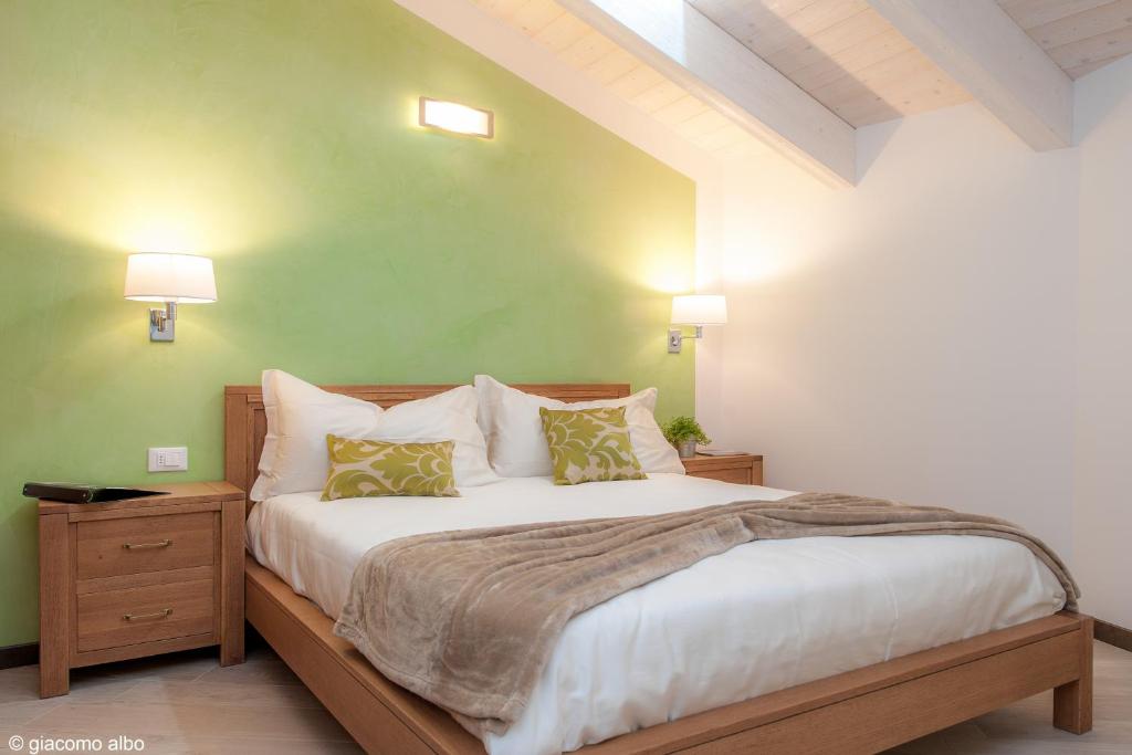 ein Schlafzimmer mit einem großen Bett mit grünen Wänden in der Unterkunft B&B Armonie del Lago in Annone di Brianza
