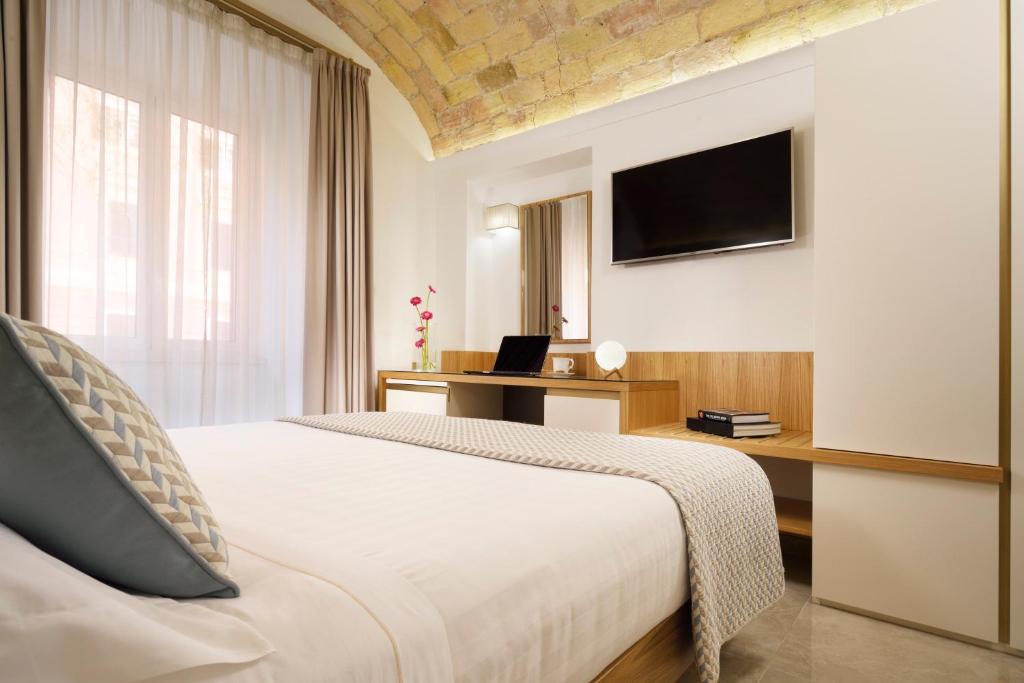 sypialnia z łóżkiem, biurkiem i telewizorem w obiekcie Magica Luna Boutique Hotel - Roma w Rzymie