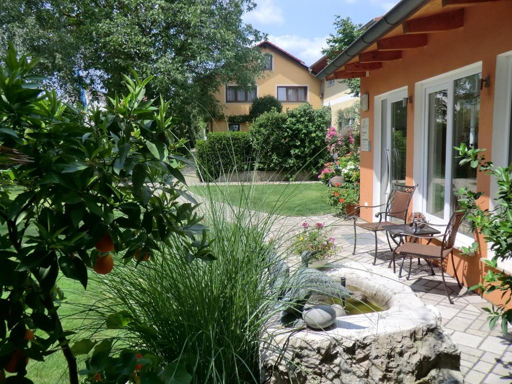 einen Garten mit einem Steinbrunnen im Hof in der Unterkunft Pension Carlbauer in Kelheim