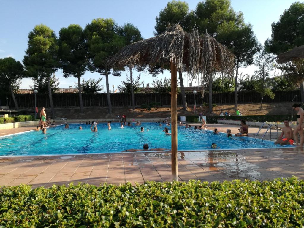 a large swimming pool with people in it with an umbrella at Camping Fayón Fishing in Fayón