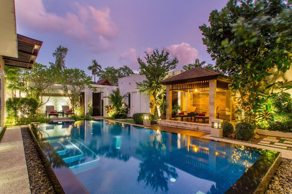 Sunset Ocean Front Villa , Mai Khao Phuket في شاطئ ماي خاو: مسبح في الحديقة الخلفية للمنزل
