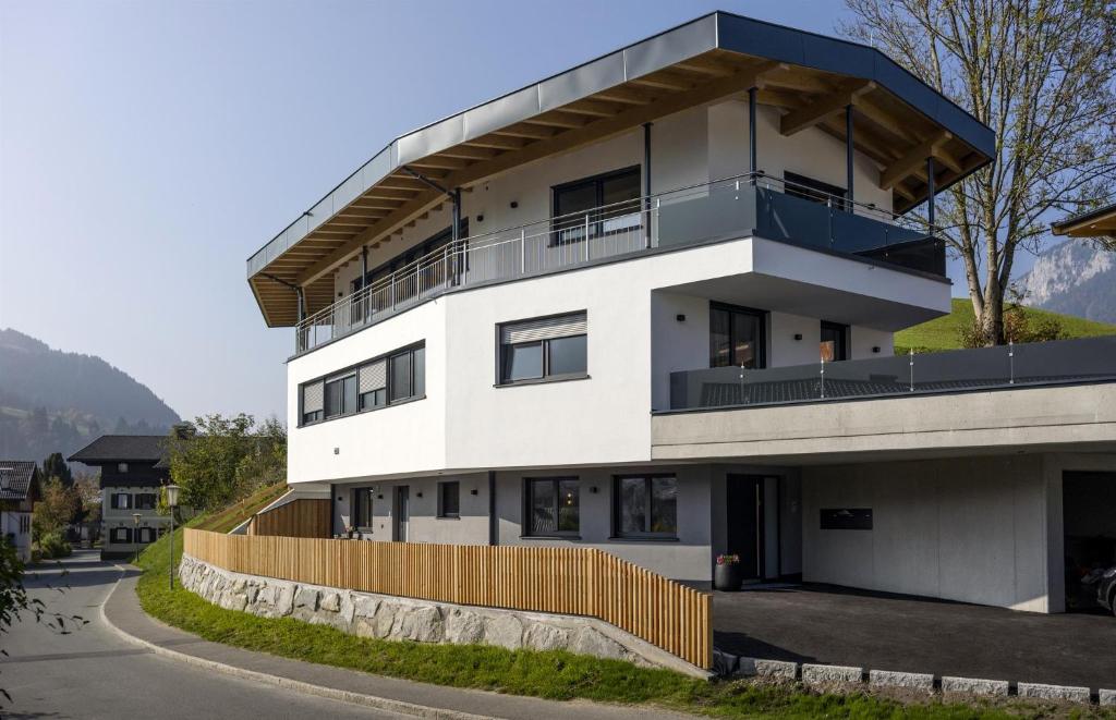 a white building with a fence in front of it at Appartement de Jager in Söll