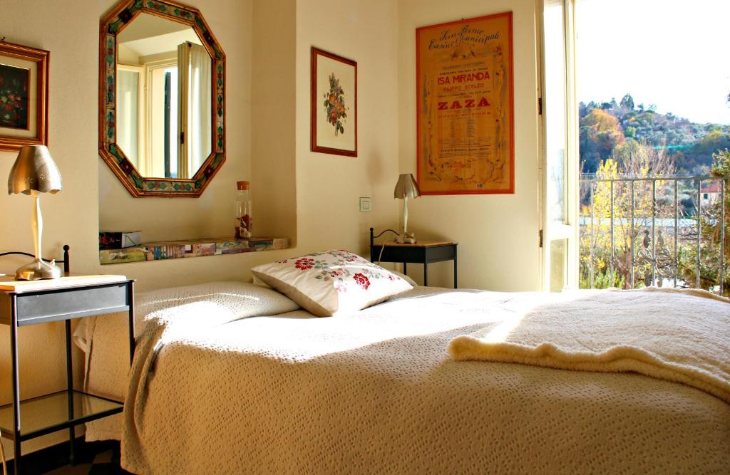 a bedroom with a bed and a mirror and a window at I Fiori di Miranda in Casarza Ligure