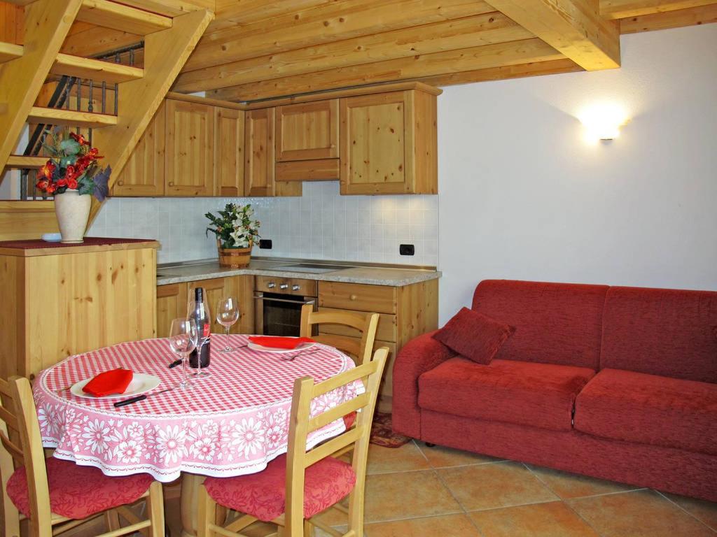 a kitchen with a table and a red couch at Baitina Viola in Valdidentro