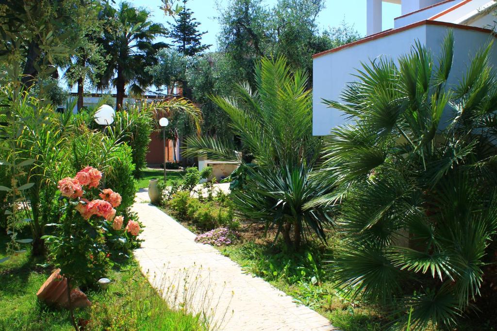 a garden with palm trees and a walkway at Green Garden Eco-Holiday in Vieste