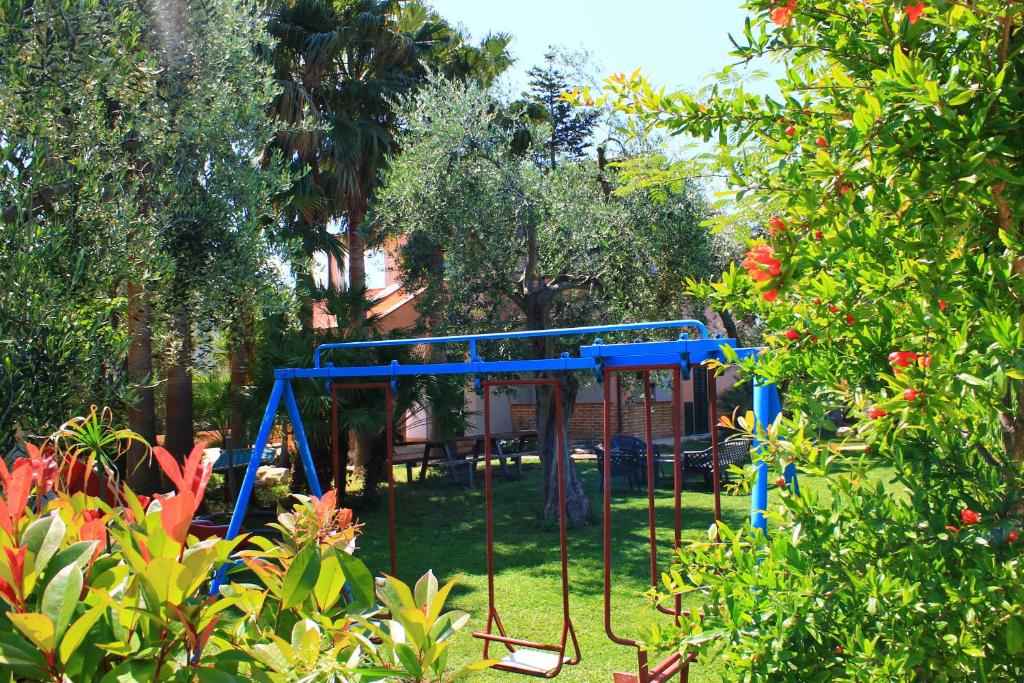 a blue playground in a yard with trees at Green Garden Eco-Holiday in Vieste