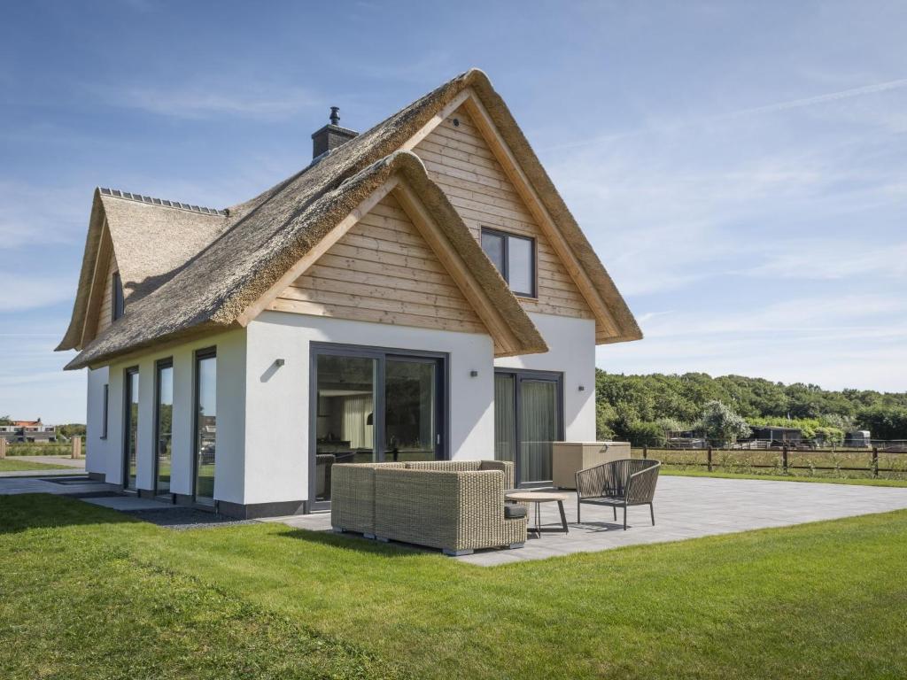 a house with a pitched roof at Lush Villa in De Cocksdorp Texel with Steambath in De Cocksdorp