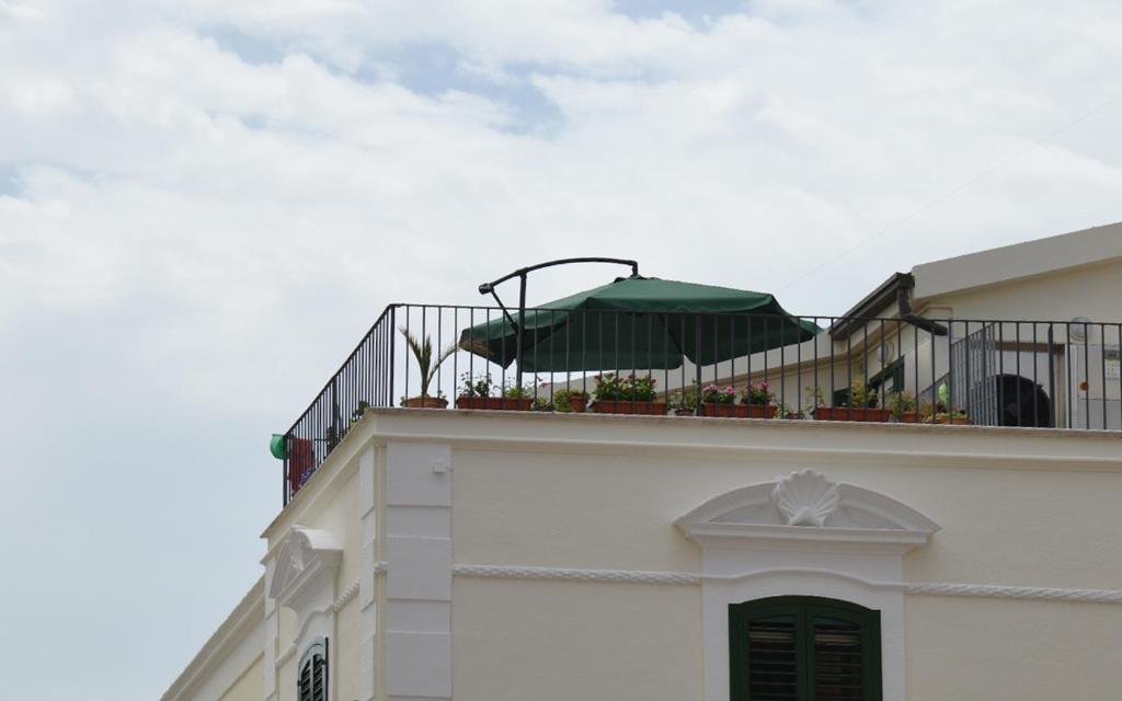 マテーラにあるアフィッタカメーレ サンフランチェスコの緑の傘を持つバルコニー付きの建物