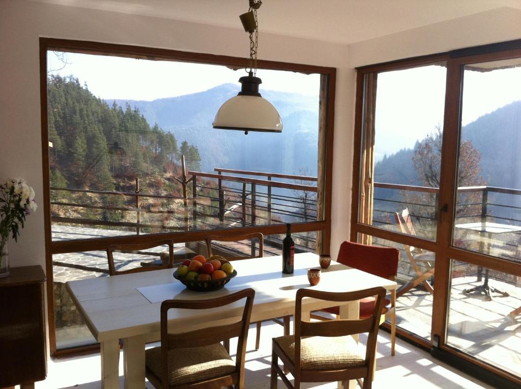 a dining room with a table and a large window at Borislav's Farmhouse in Ogled