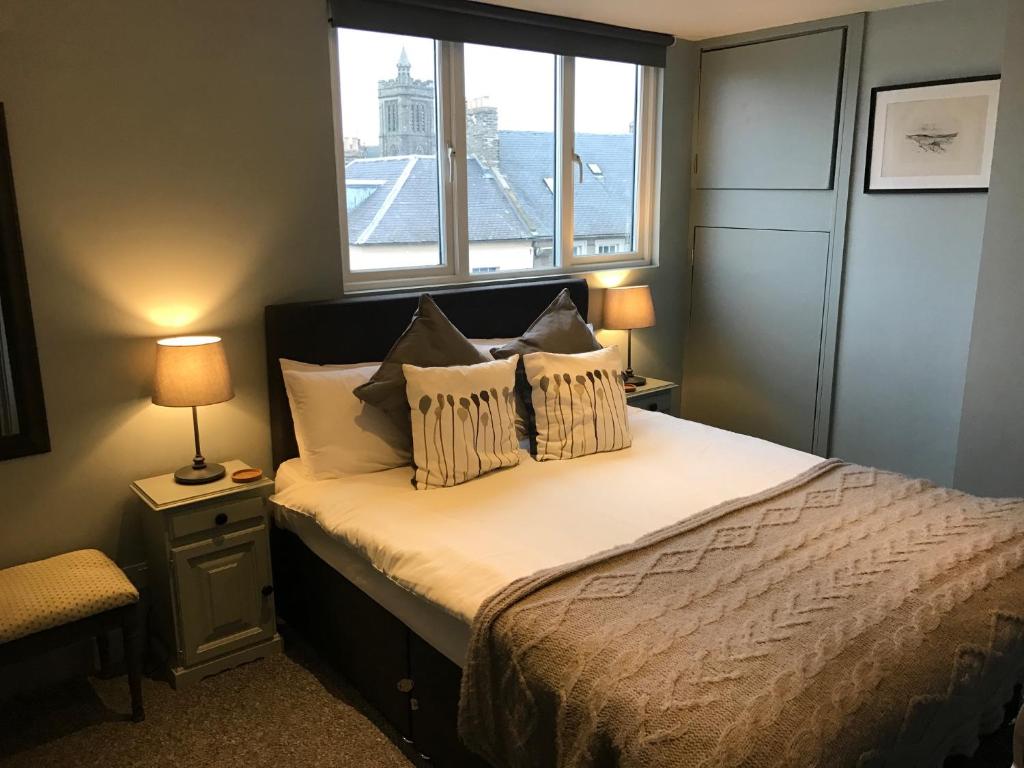 a bedroom with a bed with two pillows and a window at The Central Guesthouse in Kelso