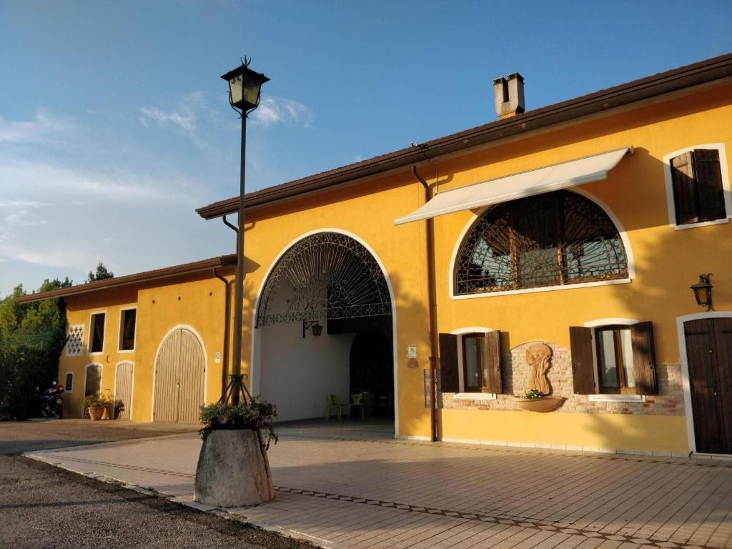 ein gelbes Gebäude mit Straßenbeleuchtung davor in der Unterkunft Agriturismo Gazza Ladra in Noventa di Piave