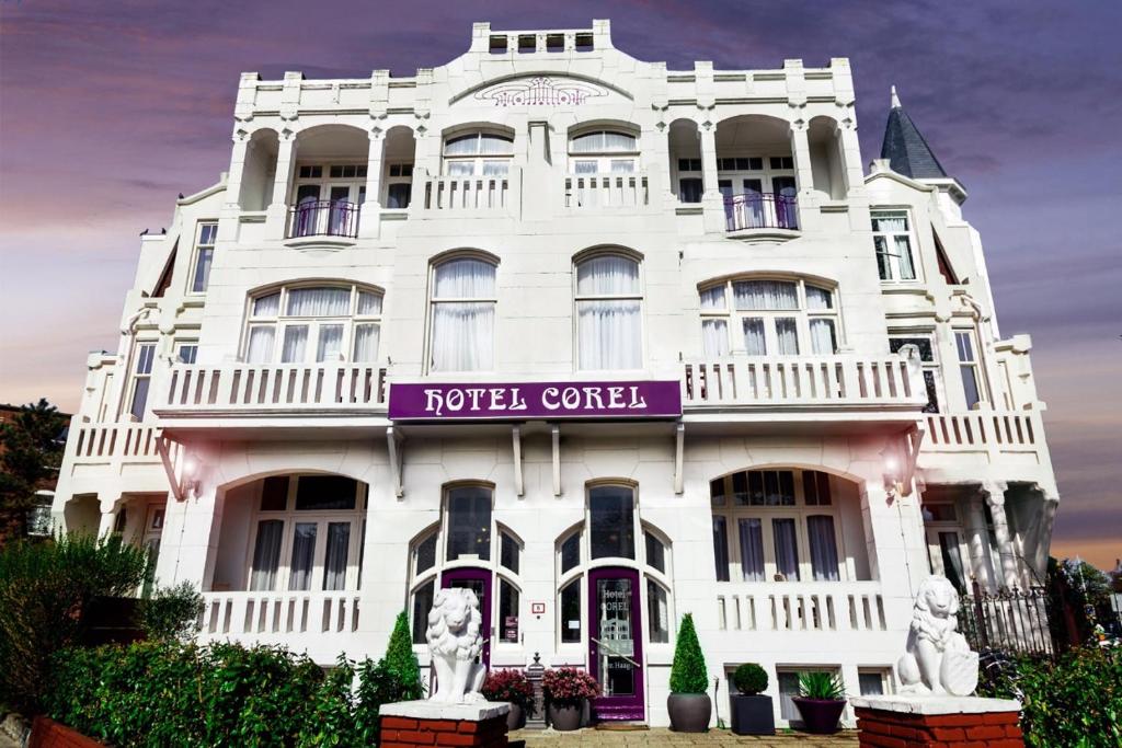 a white building with a purple sign on it at Hotel Corel in Scheveningen