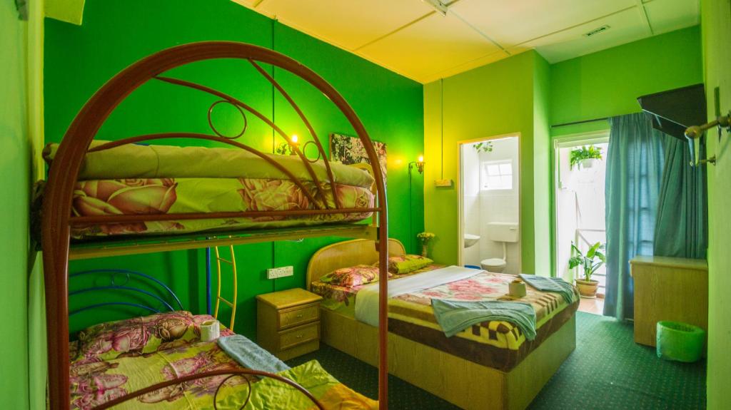 a bedroom with two bunk beds and green walls at Orchid Haven in Cameron Highlands