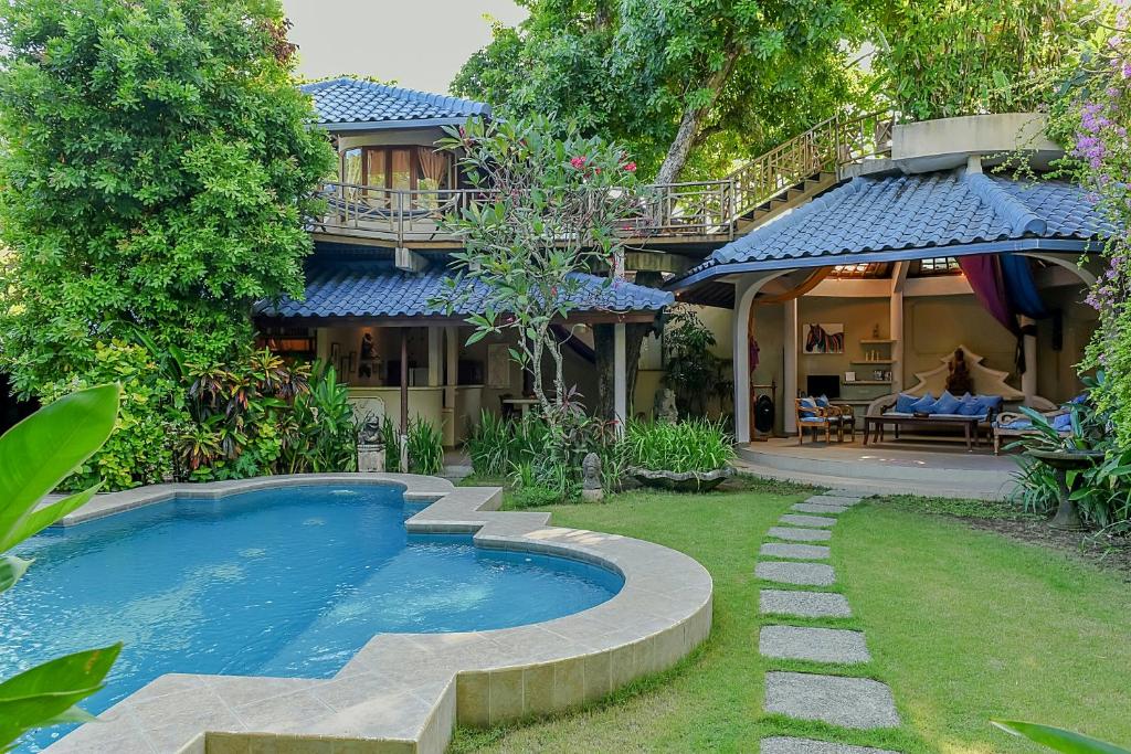 a house with a swimming pool in the yard at Ben Bali Villa in Seminyak