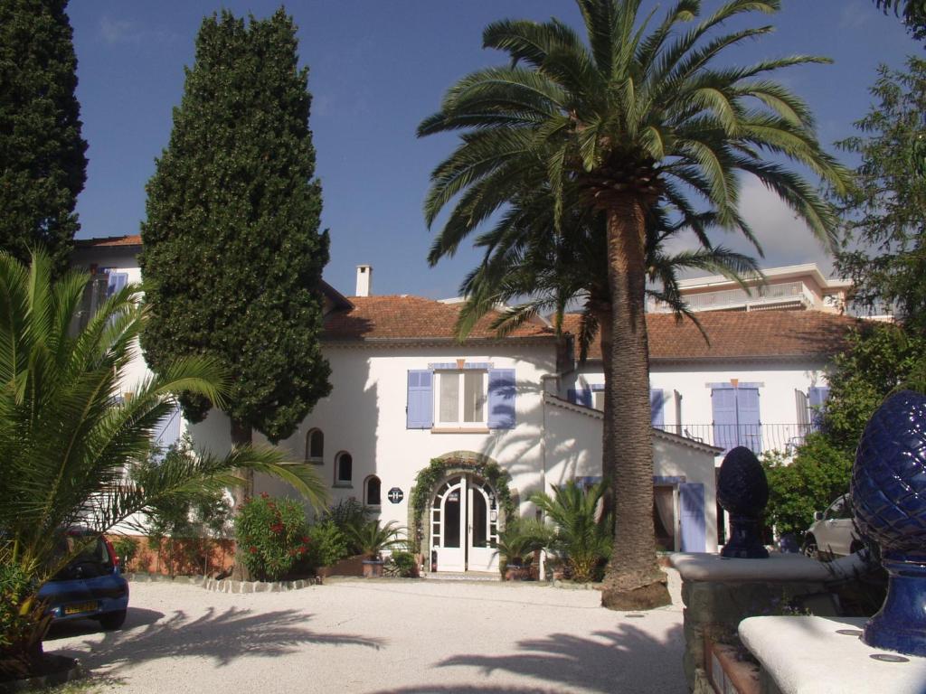 une maison avec un palmier en face dans l'établissement Hotel Villa Provencale, à Cavalaire-sur-Mer